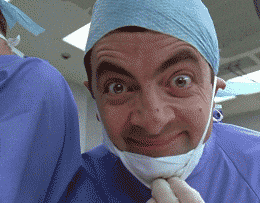 Mr Bean en tenue de bloc opératoire, grimaçant face caméra